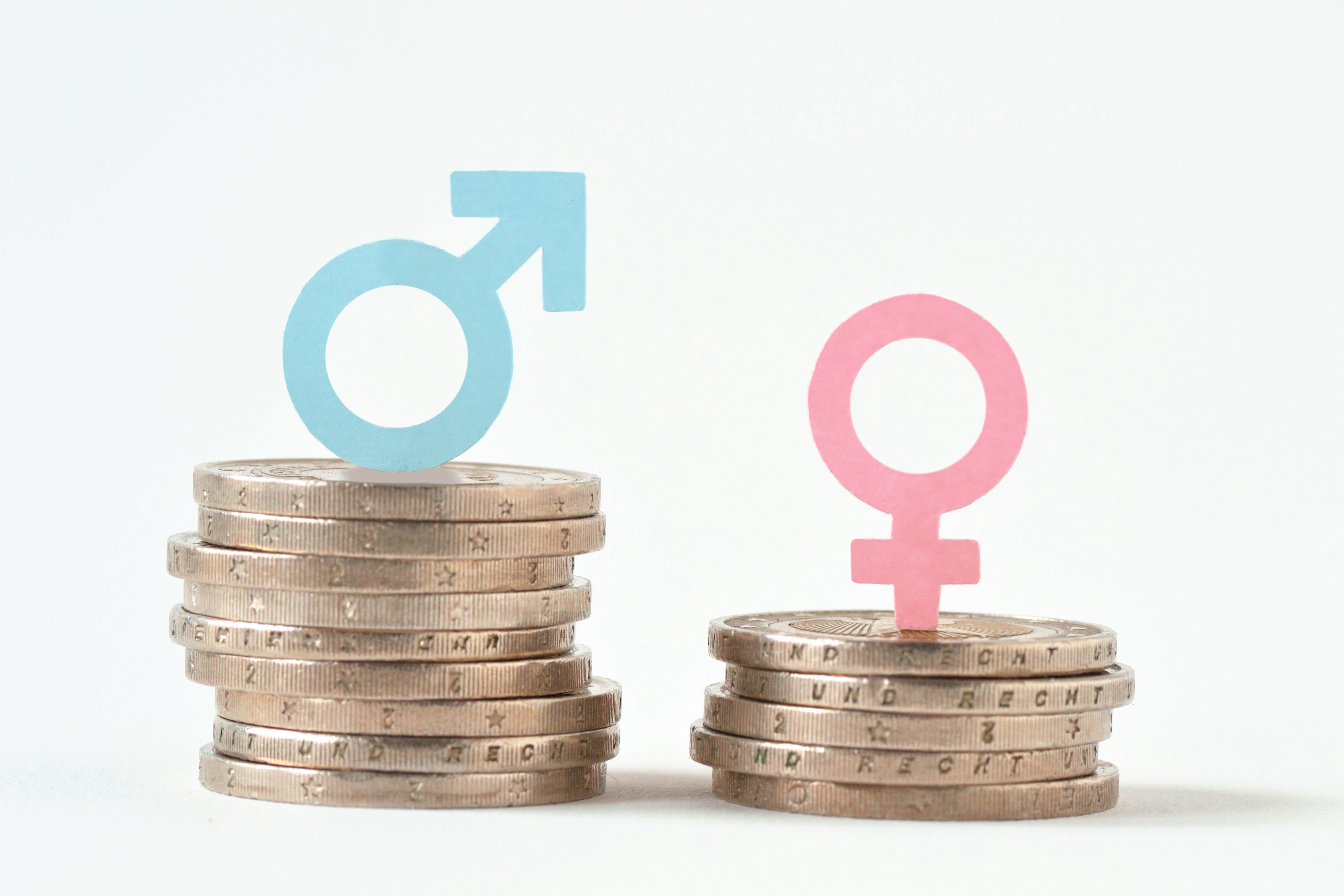 Male and female symbols on piles of coins - Gender pay equality concept