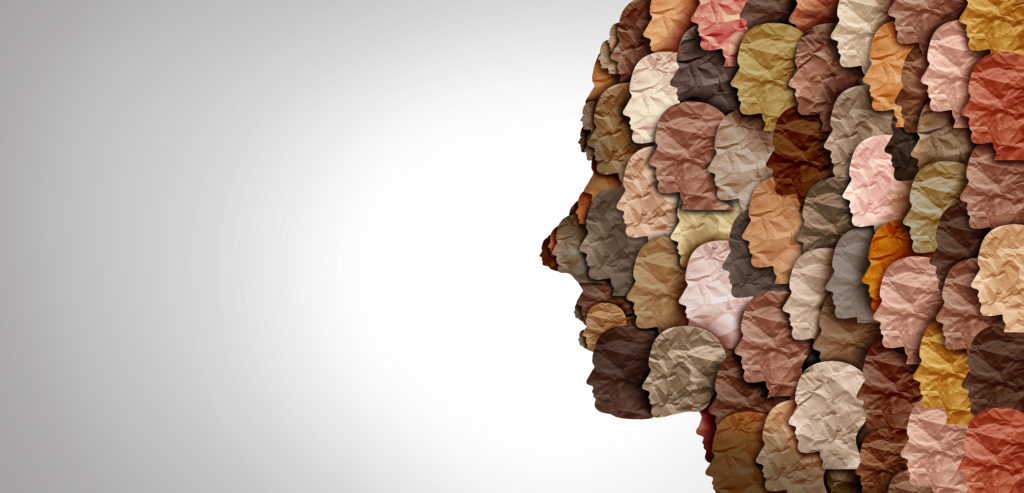 Image Showing silhouette of face side profile, made up of many other smaller faces of different colour in front of a grey background